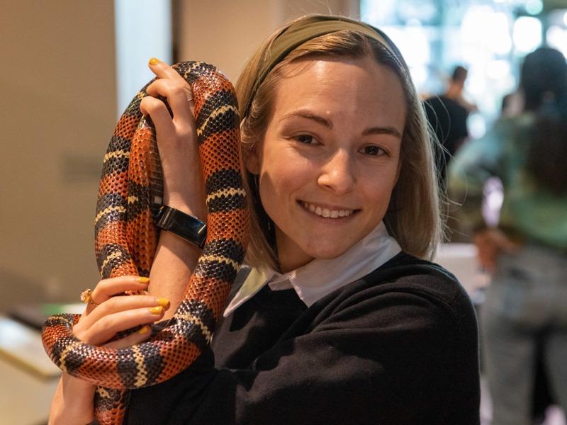 在达尔文日，一位年轻女子举着一条蛇.